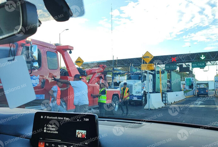 ¿A dónde con tanta prisa? Tráiler se atora en caseta de cobro de Taretan