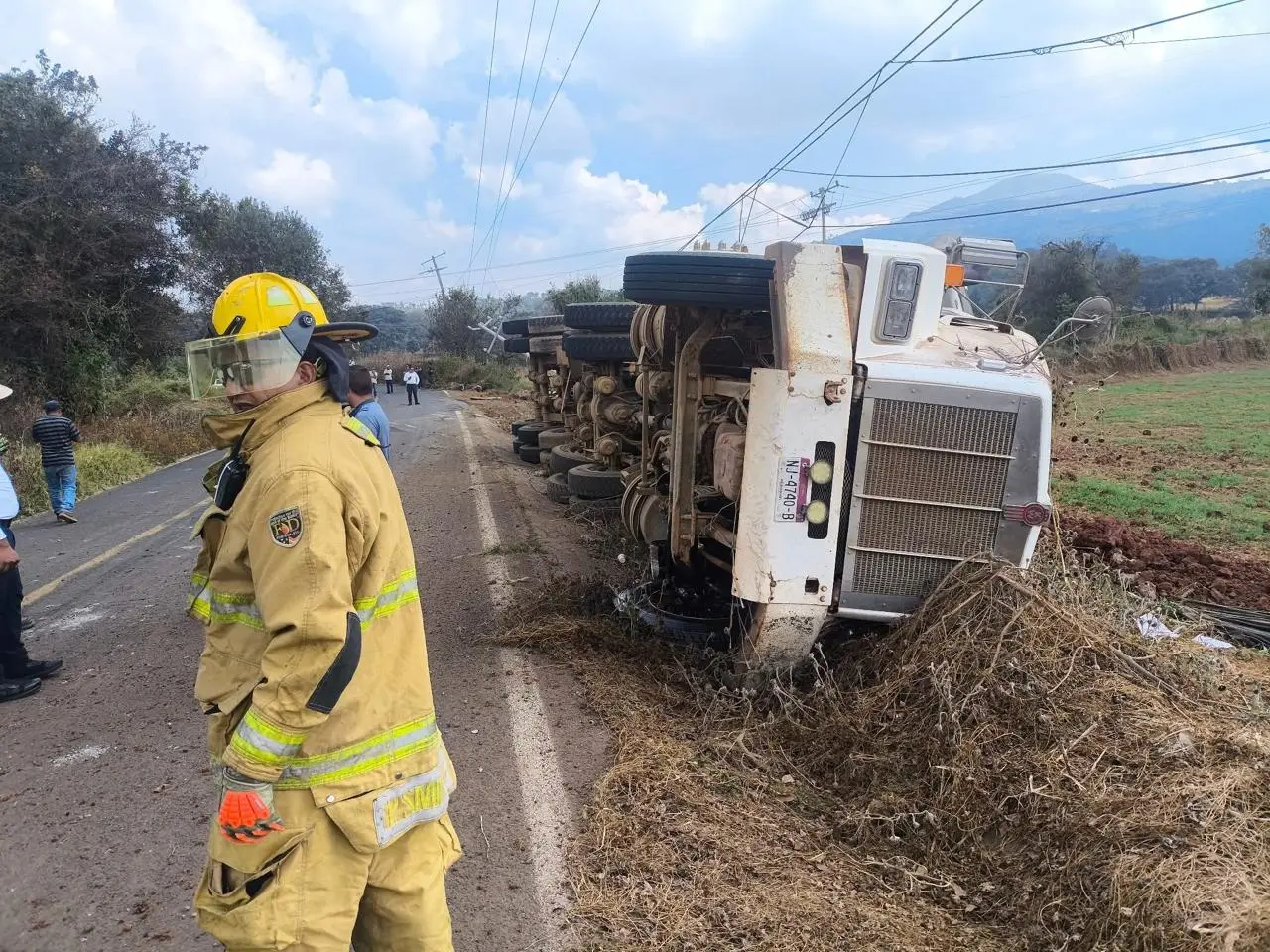 Tráiler se vuelca por exceso de carga en la Purépero – Caurio y derriba postes de la FGE; Conductor resulta ileso